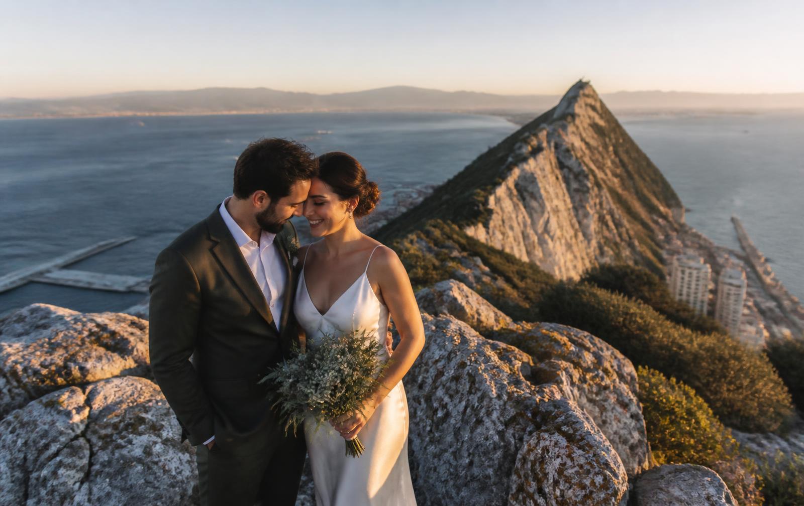 Just-married couple at sunset above the Rock of Gibraltar